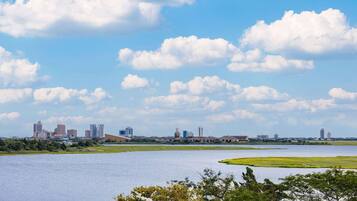 A city skyline with modern buildings and a large body of water in the foreground.