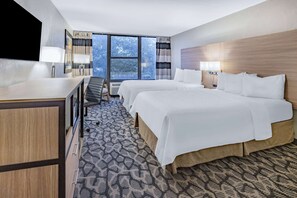 A hotel room with a large bed, a desk, and a TV. - Ramada by Wyndham West Atlantic City (Pleasantville)