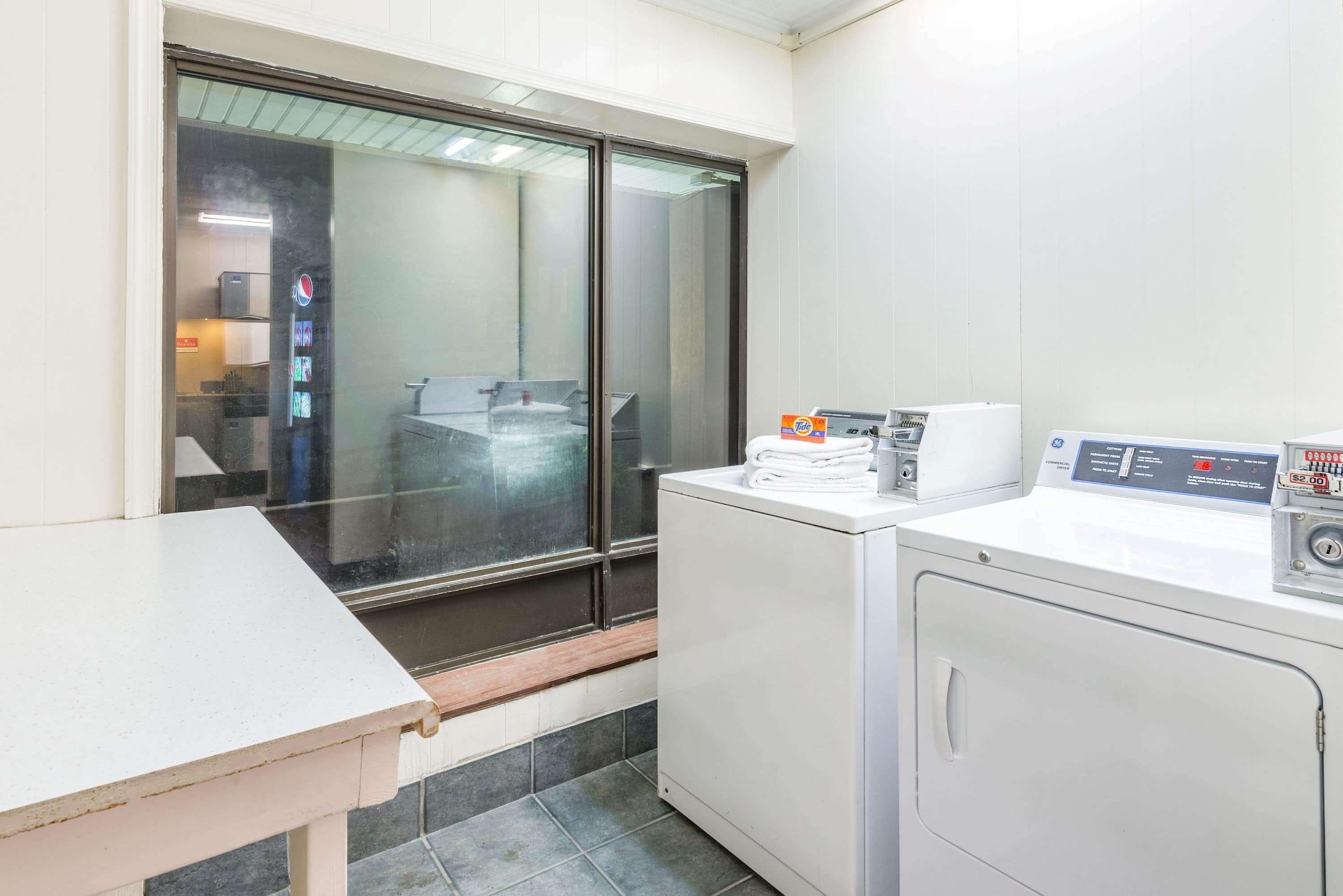 A laundry area with a washing machine, a dryer, and a table.