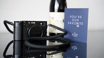 A camera, a wine bottle, and a card with text.
