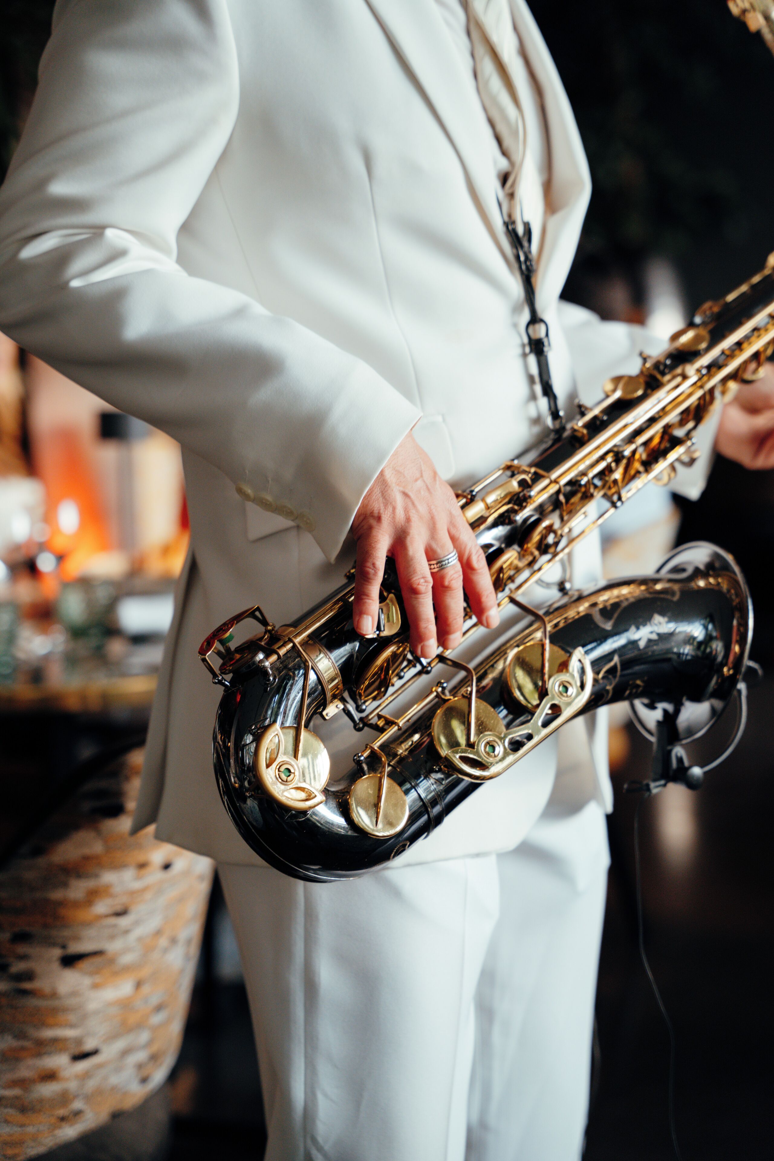 A person in a white suit holding a saxophone.