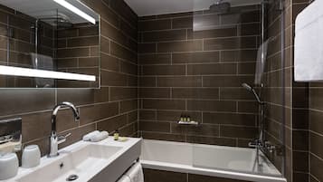 A modern bathroom with a glass-enclosed shower, a white sink, and a large mirror.