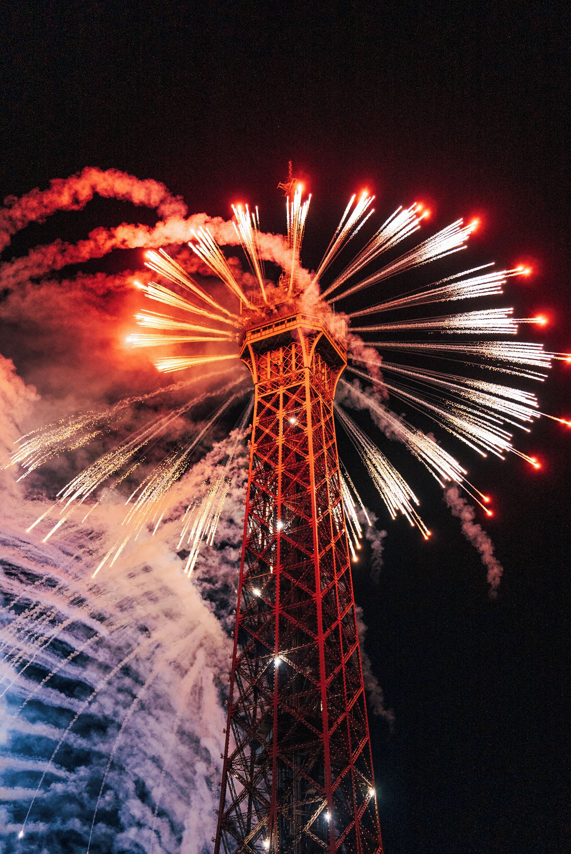A tower with fireworks in the background.