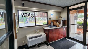 L'intérieur d'un café, avec un comptoir, un climatiseur ProSpace et une fenêtre sur laquelle est affiché un panneau indiquant « OUVERT ».