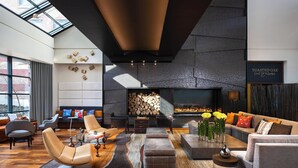 Un salon moderne avec une cheminée, des canapés en cuir et une grande fenêtre.