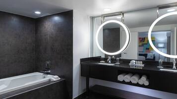 Un baño moderno con bañera, tocador con espejo y barra para toallas.