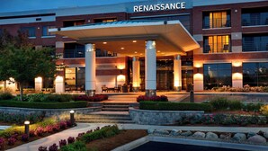 Un hôtel moderne doté d’une entrée couverte, d’un espace extérieur aménagé et de jardins paysagers.