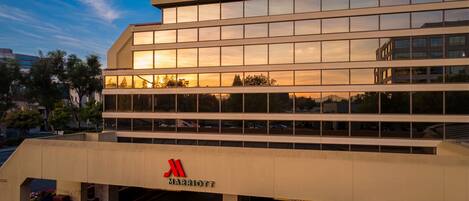 A multi-story building with a Marriott logo, large windows, and a flat roof.