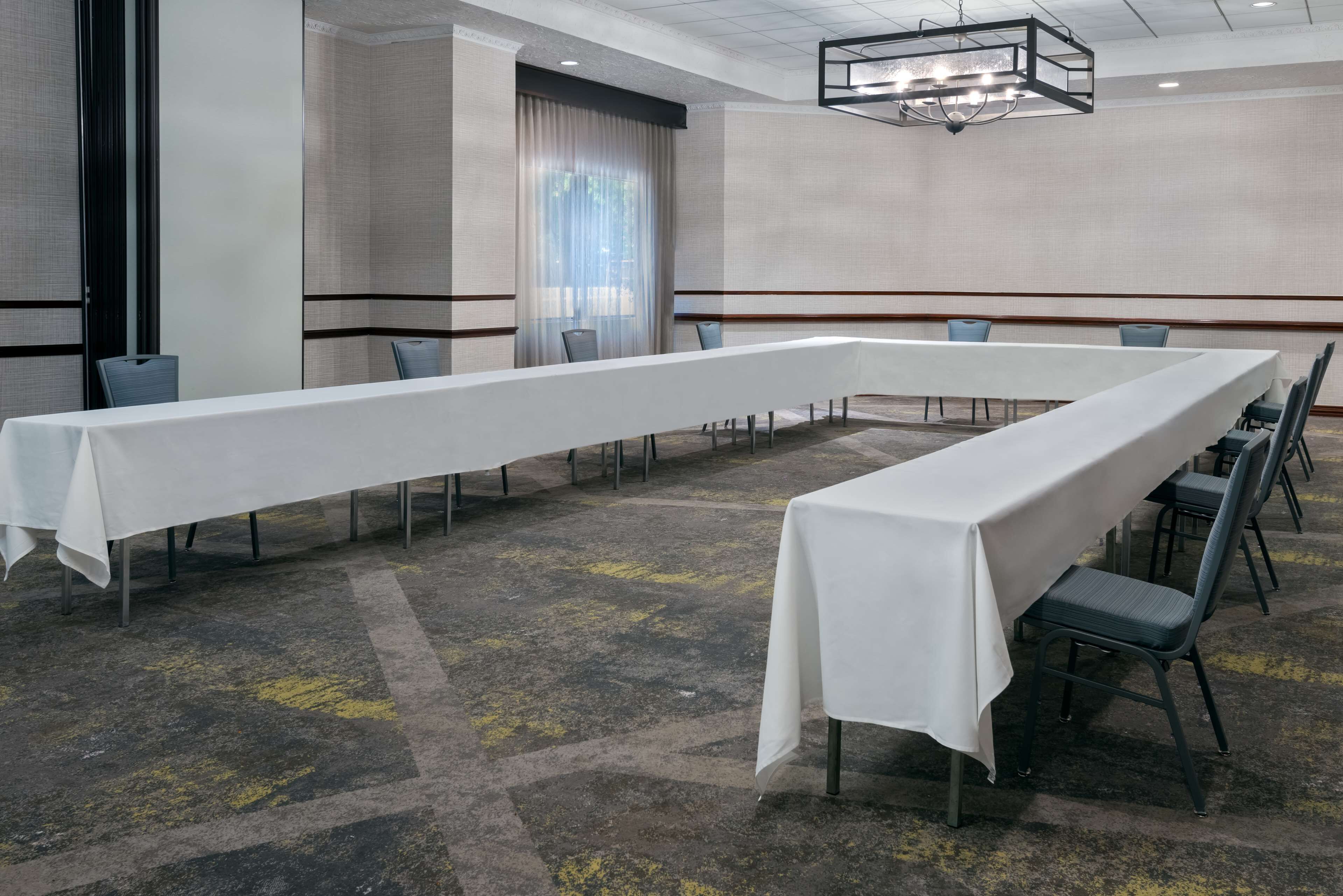 A conference room with a long table, chairs, and a chandelier.
