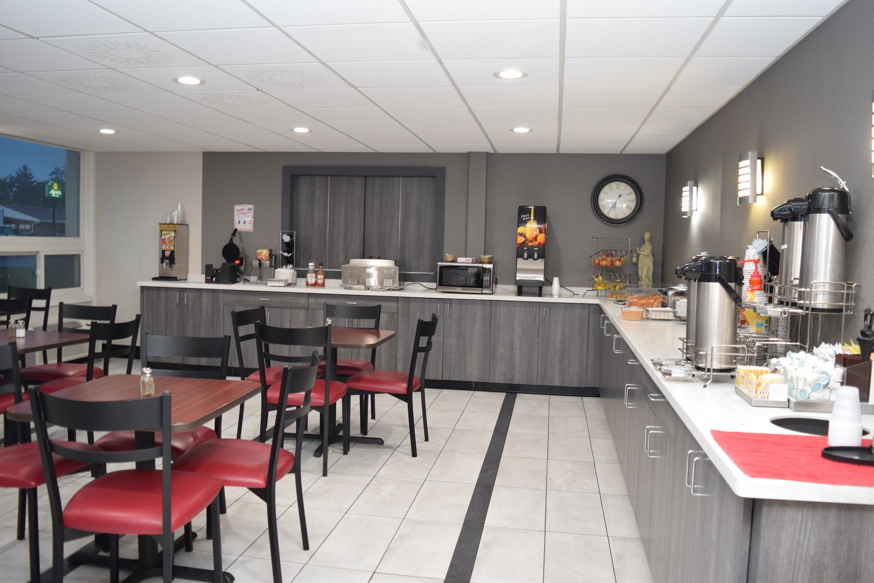A modern restaurant with a central island, seating area, and various kitchen appliances.