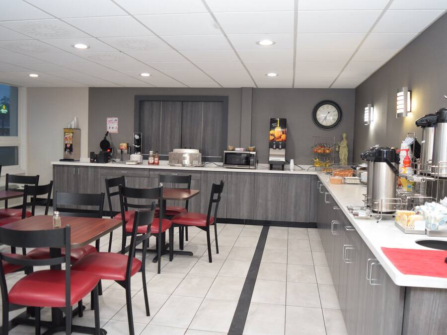 Un café moderno con una isla central, zona de estar y diversas máquinas expendedoras de comida y bebidas.