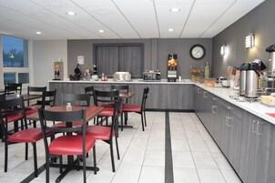 Una cafetería moderna con una isla central, zona de estar y electrodomésticos de cocina.