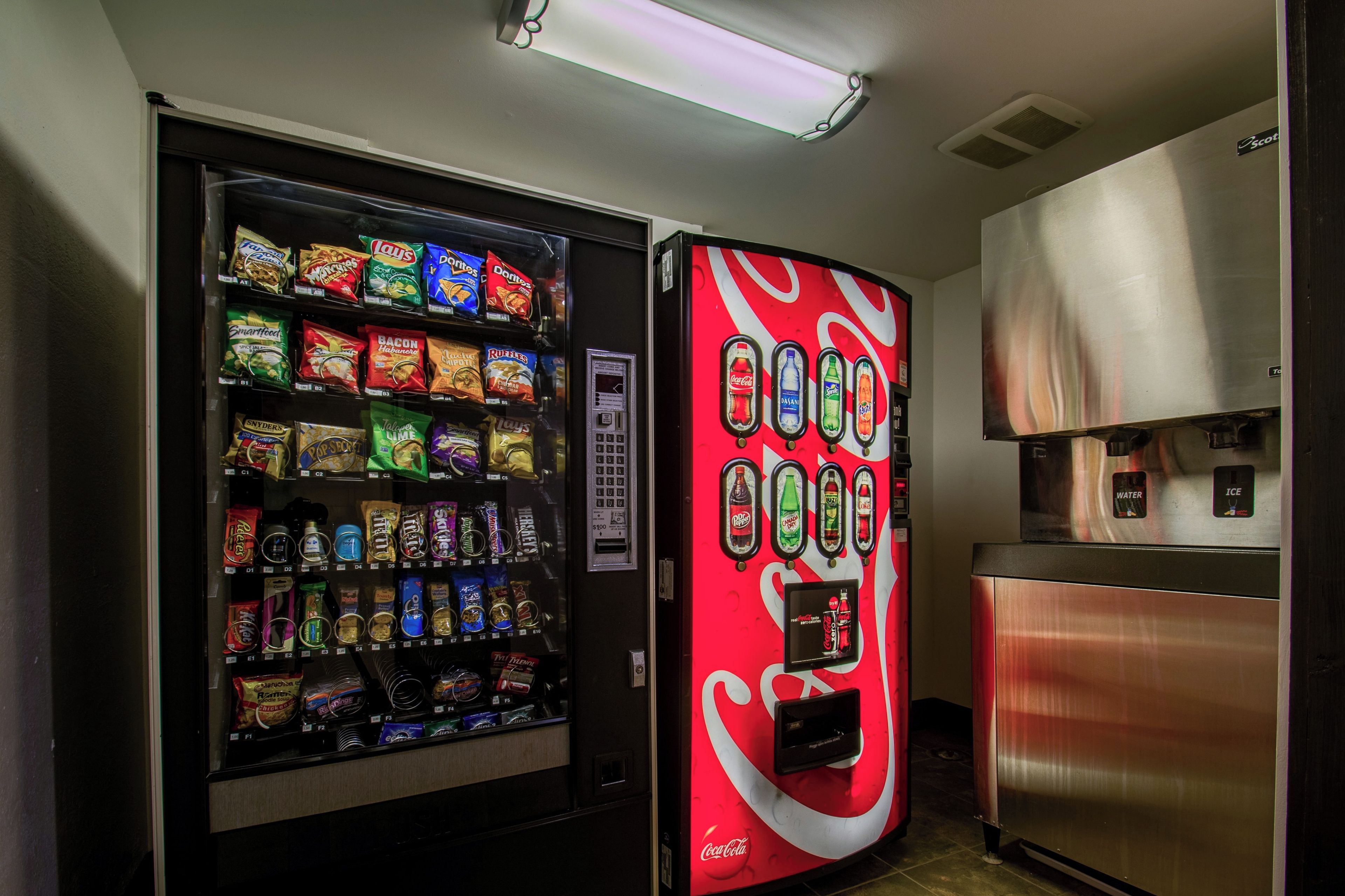A vending machine with snacks and a Coca-Cola machine.