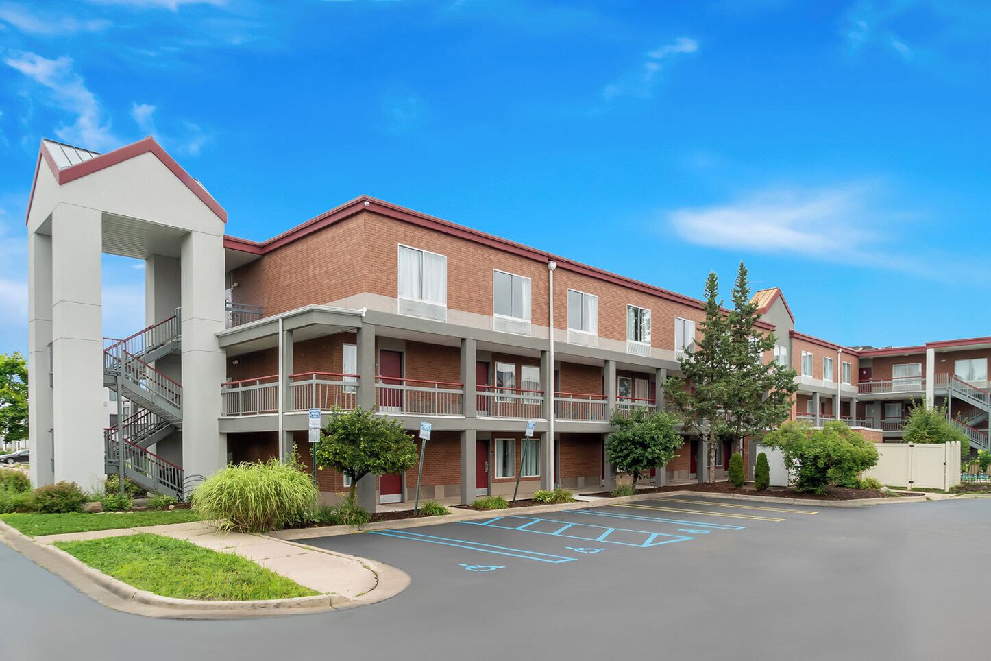 A multi-story residential building with a central courtyard, balconies, and a parking area with handicapped accessibility.