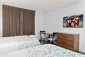 A hotel room with two beds, a desk, and a chair.