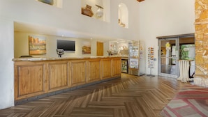 A spacious kitchen with wooden cabinets, a herringbone floor pattern, and a stone accent wall.