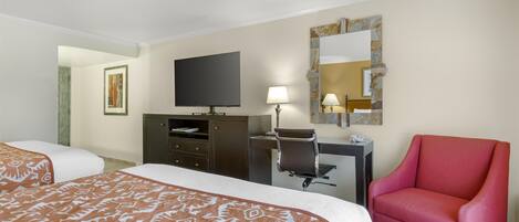 Une chambre d’hôtel avec deux lits, un bureau, une chaise, une télévision et un miroir.