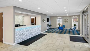 A reception area with a tiled floor, a reception desk, and a seating area with chairs.