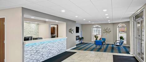 A reception area with a tiled floor, a reception desk, and a seating area with chairs.