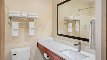 Un baño con inodoro, lavamanos y perchero para toallas.