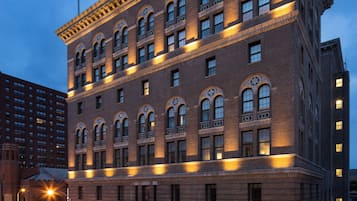 A multi-story hotel with a classic architectural style, featuring arched windows and decorative trim.