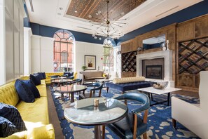A modern lounge area with a fireplace, seating arrangements, and a patterned carpet. - Hotel Indigo Baltimore Downtown by IHG (Baltimore)