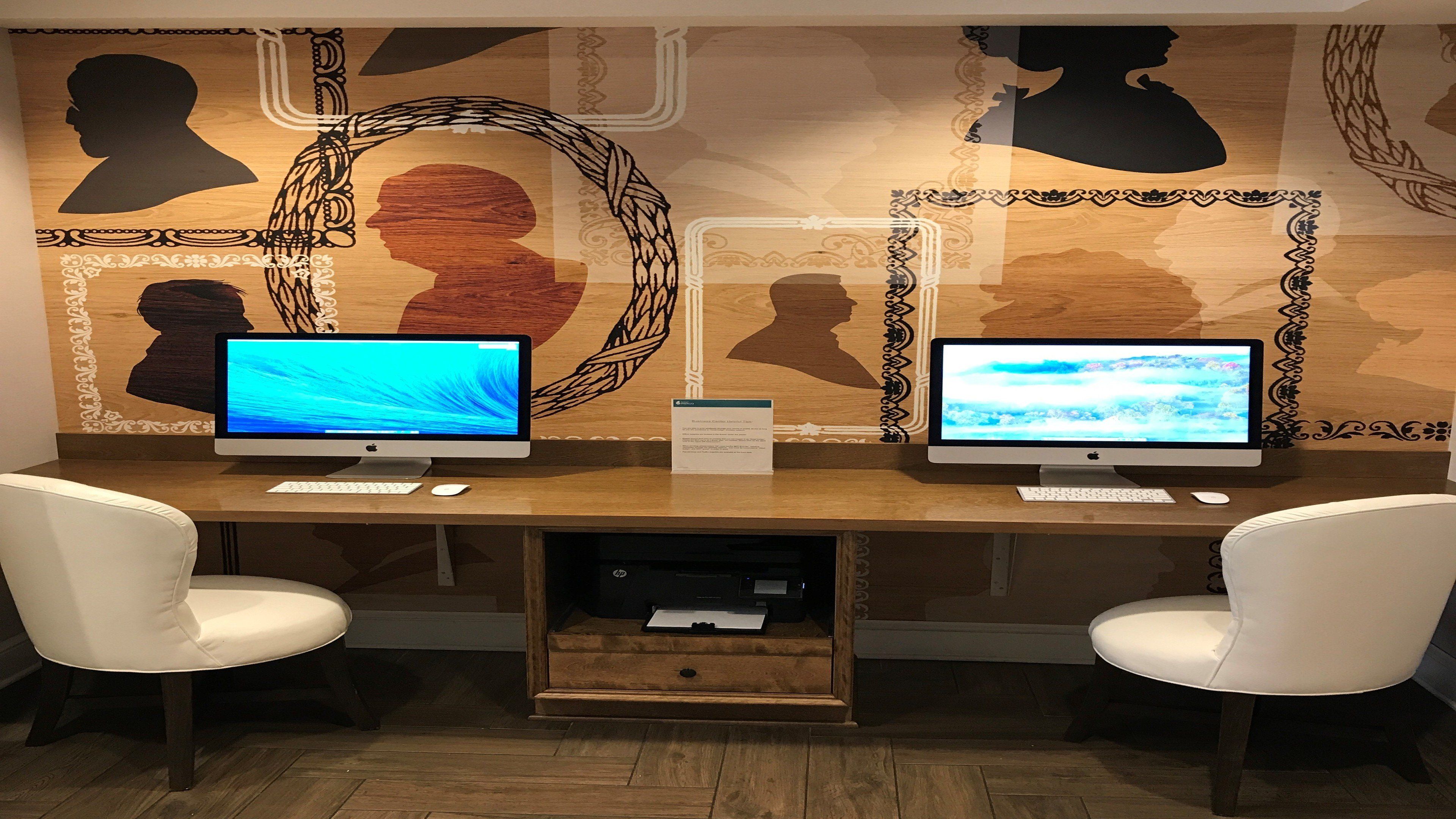 A workspace with two monitors, a keyboard, a mouse, and two chairs.