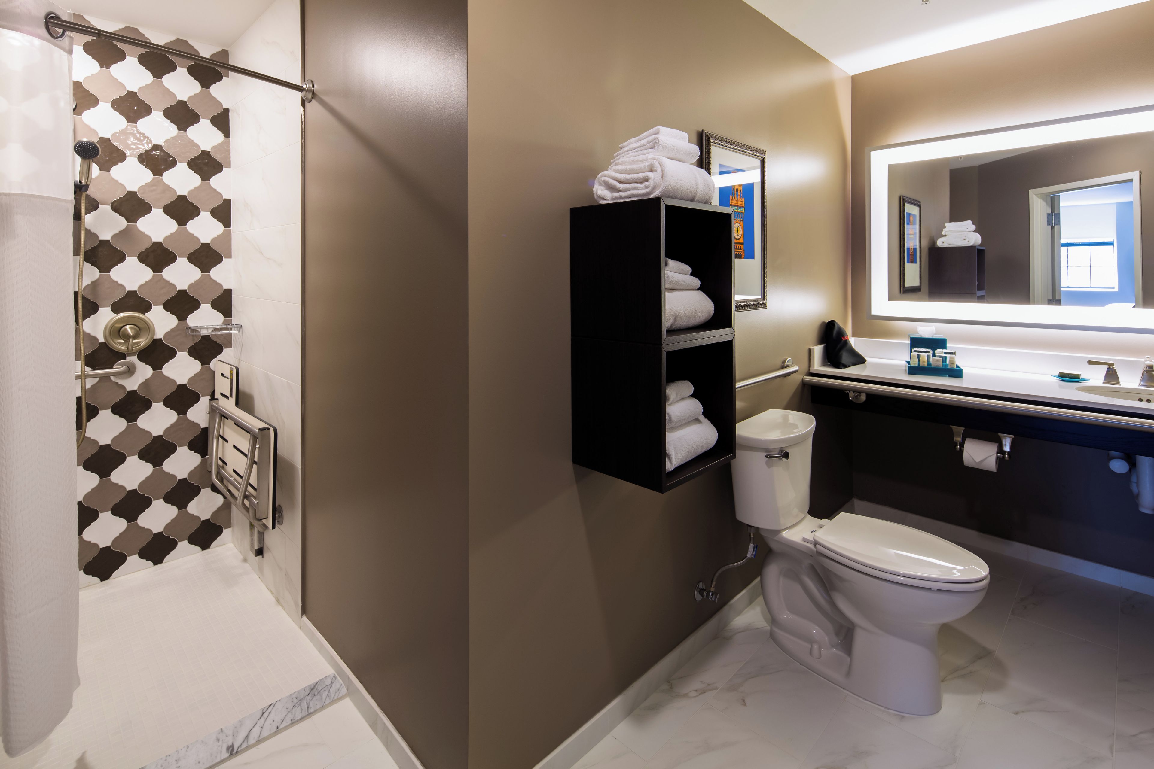 A modern bathroom with a shower, toilet, and vanity.