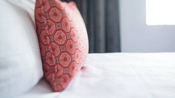 Ein Detailaufnahme eines geblümten Kissen auf einem Bett.