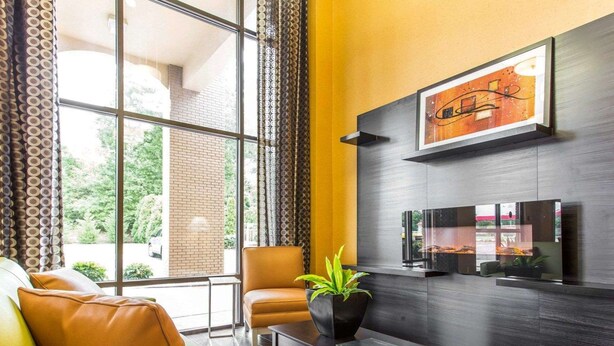 Een moderne woonkamer met leren banken, een salontafel en een aan de muur bevestigde televisie.