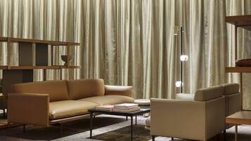 Una sala de estar moderna con sofá, sillón, mesa de centro y estantería.