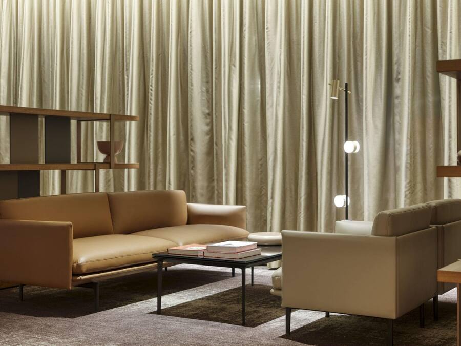 Una sala de estar moderna con sofá, sillón, mesa de centro y estantería.