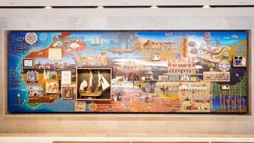 A large, colorful mural with various scenes and objects, including a ship, buildings, and natural landscapes.