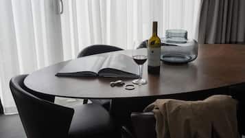 A round table with a book, a wine bottle, and a glass.
