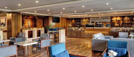 A hotel lobby with seating areas, a bar, and a reception desk.