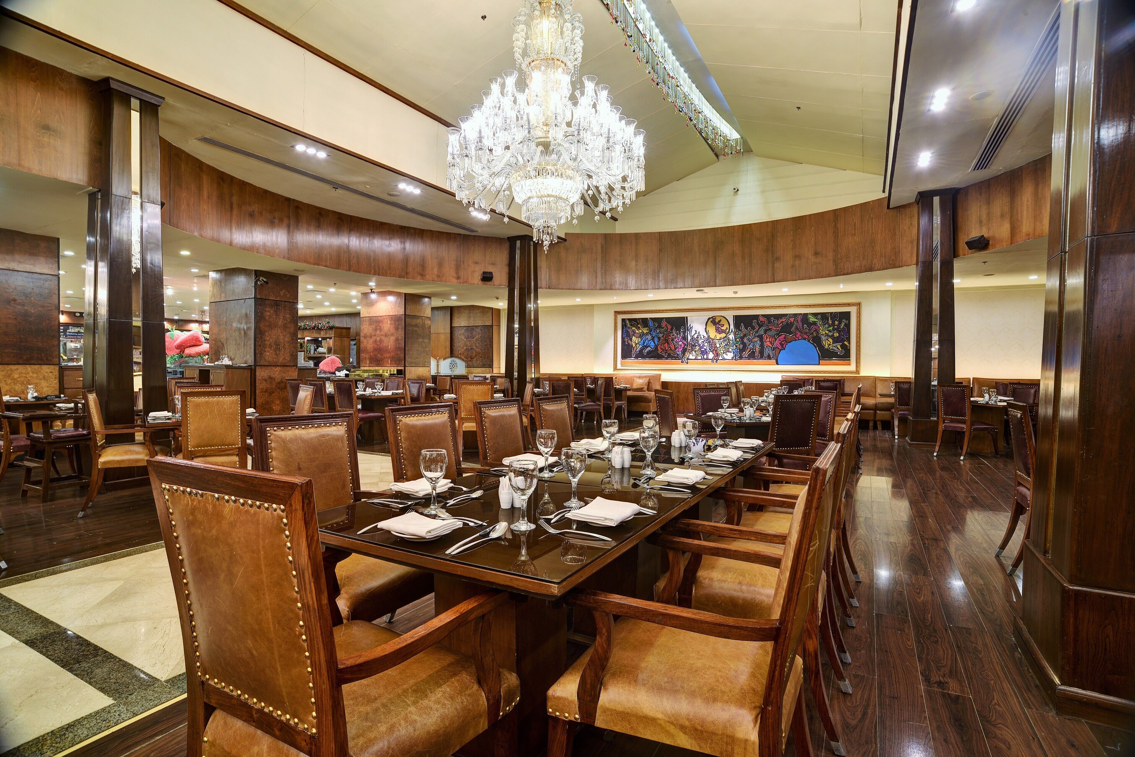 Un comedor amplio con una larga mesa dispuesta para una comida, rodeada de sillas de madera.