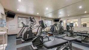 Un gimnasio con cintas de correr, elípticas y bancos de pesas.