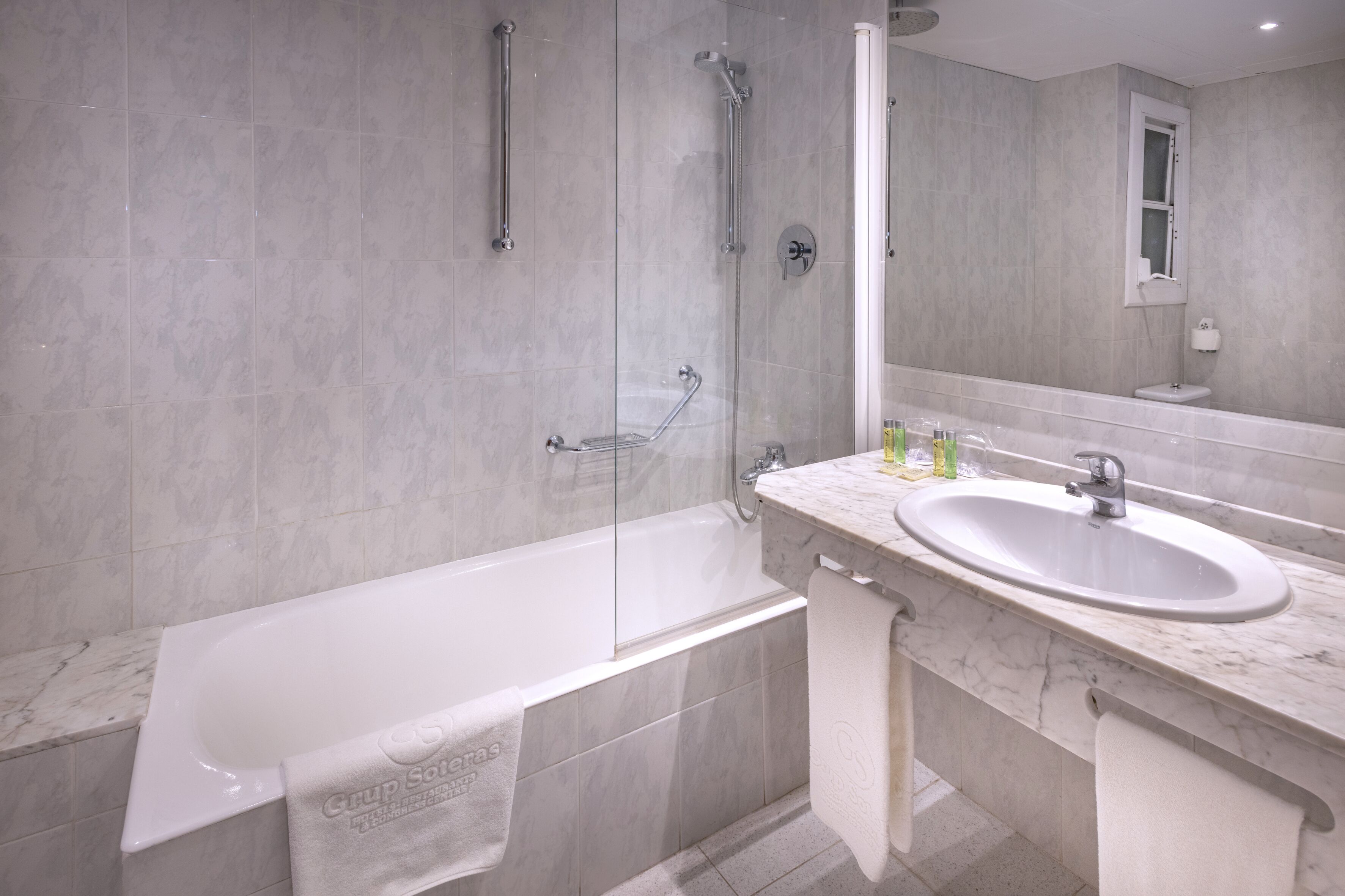 A modern bathroom with a bathtub, a sink, and a shower area.