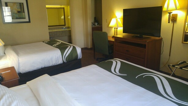 A hotel room with two beds, a television, a desk, and a chair. - Quality Inn & Suites Covington (Covington)