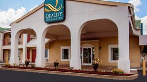 A hotel with a sign reading "Quality Inn & Suites". It features a covered entrance with arches and potted plants. - Quality Inn & Suites Covington (Covington)