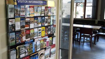 A visitor information board with brochures, a ceiling fan, and a dining area with tables and chairs.