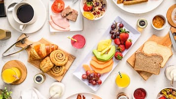 Un bufé de desayuno con diversos alimentos y bebidas.