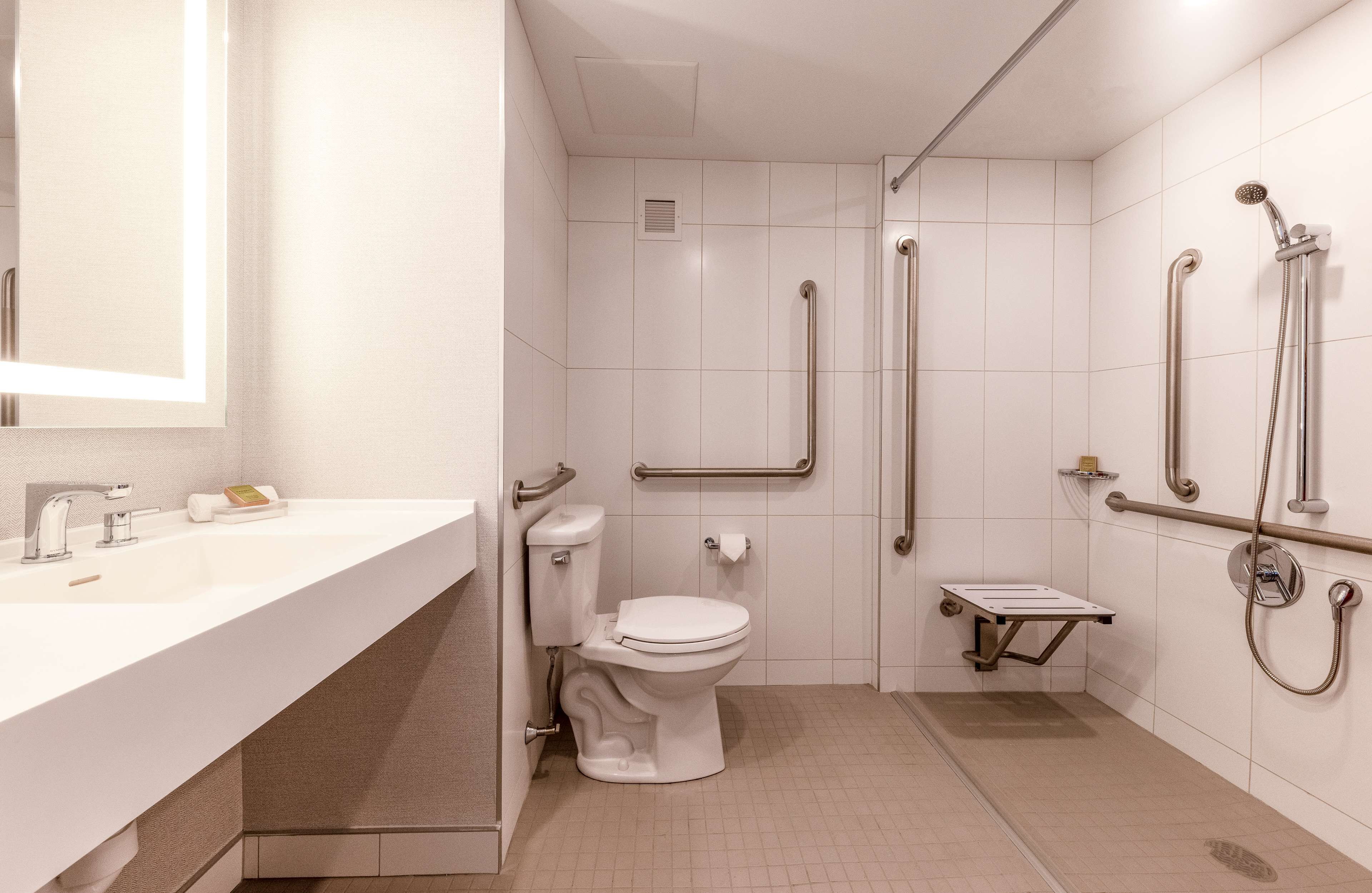 Et moderne badeværelse med vask, toilet og bruseområde.