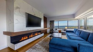 A modern living room with a fireplace, a large TV, and a sofa.