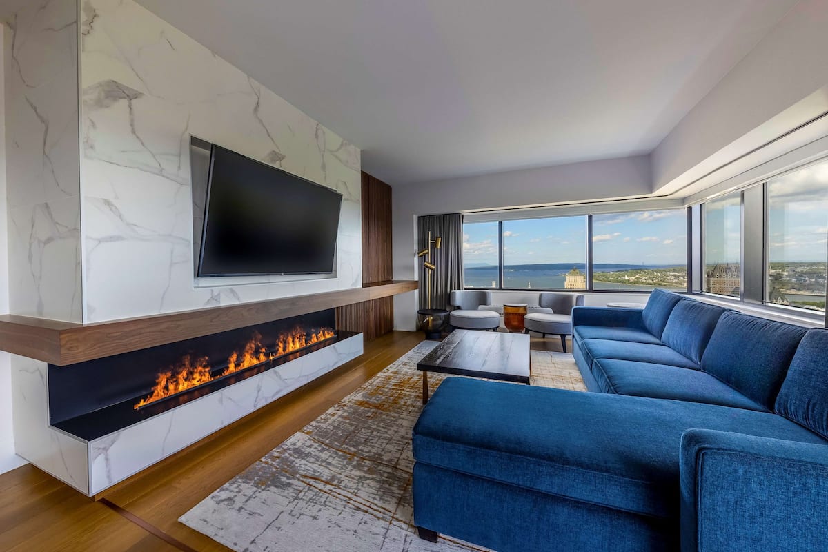 A modern living room with a fireplace, a large TV, and a sofa.