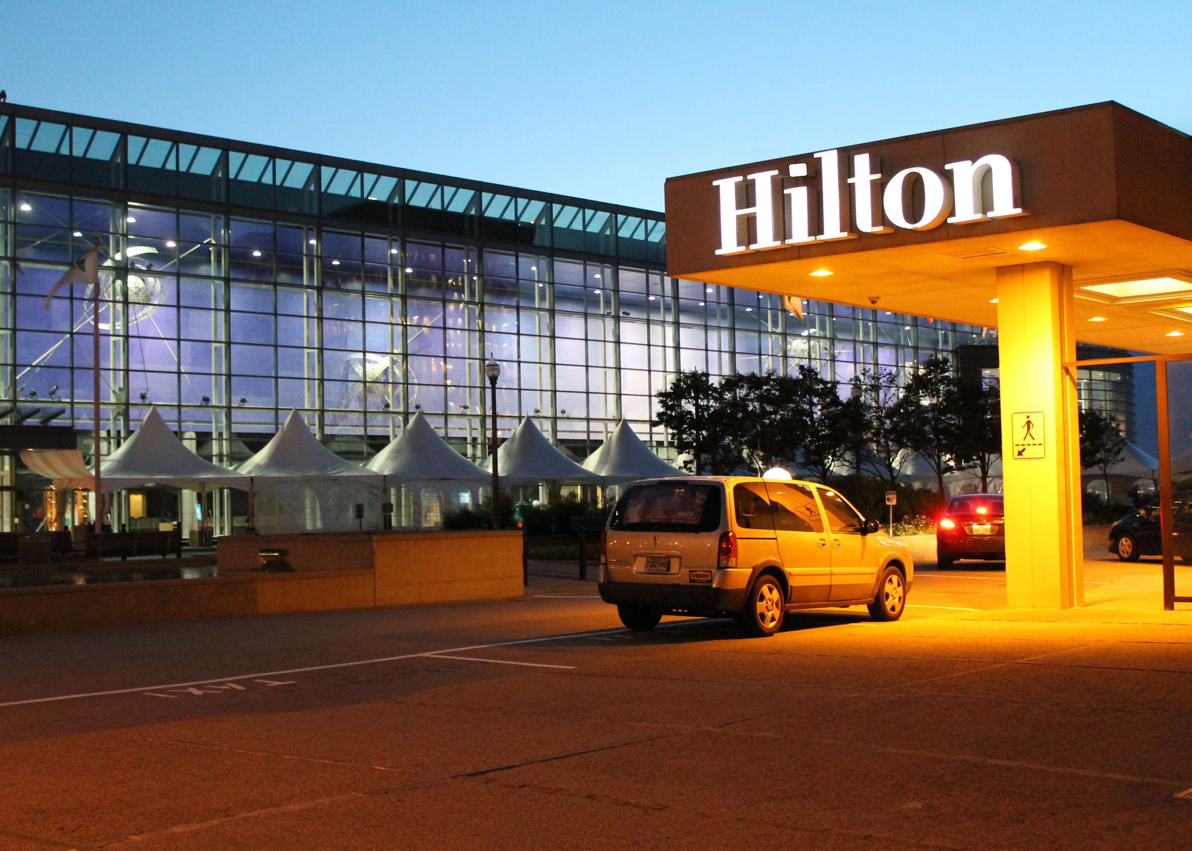 A Hilton hotel entrance with a modern glass facade and a canopy over the entrance.