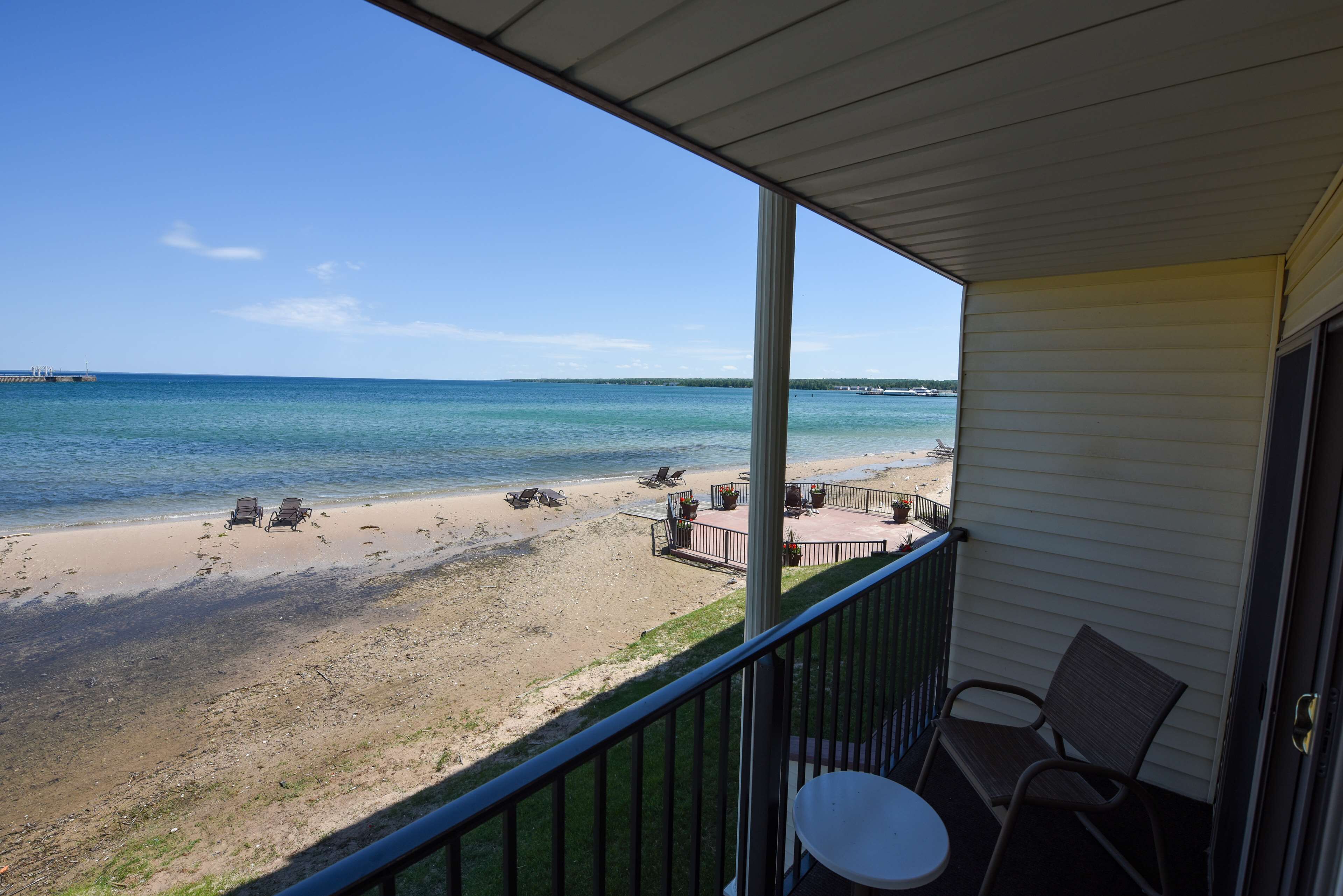 A balcony with a view of a beach and ocean.