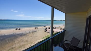 A balcony with a view of a beach and ocean.