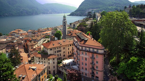 Une ville côtière dotée de bâtiments historiques, d’une tour imposante et d’un lac.