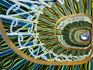 A spiral staircase with a zebra-striped pattern and a wooden handrail. - ibis Styles Paris République (Paris)
